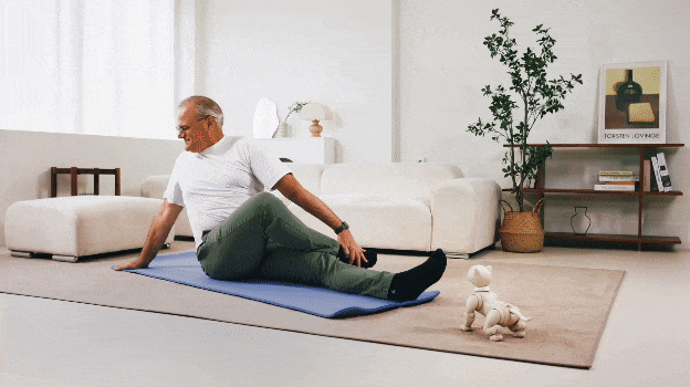 Senior works out infront of robot cat.